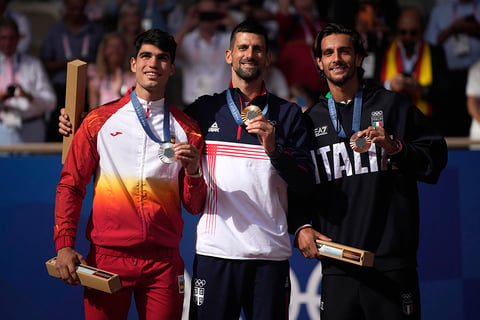 Gold medalist Novak Djokovic, center, silver medalist Carlos Alcaraz, left, and bronze medalist Lorenzo Musetti